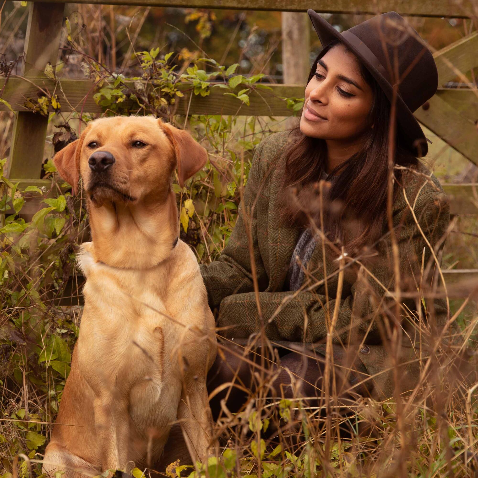 Women and Labrador sitting in the long grass