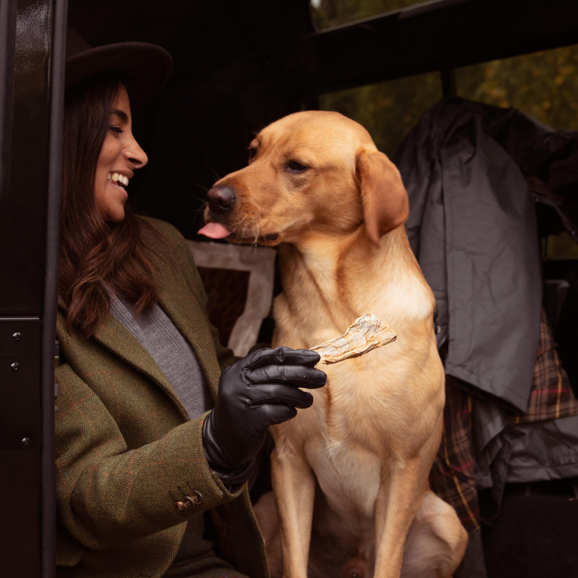 Women enjoy feeding her Labrador with Essential foods dog treat