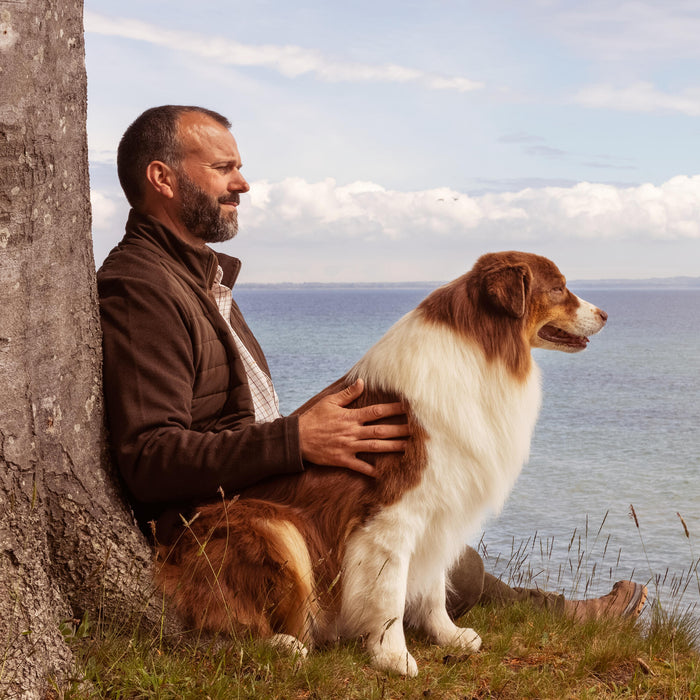 Man and his dog looking into the ocean